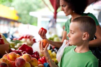 boy at the farmer's market for peaches