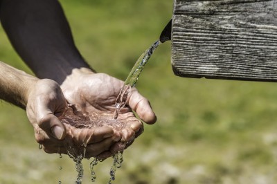 Thirsty Hands Taking Water From Well