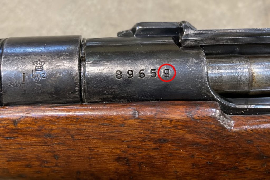 Close-up of a Mauser receiver stamped bnz with serial number 8965g circled in red
